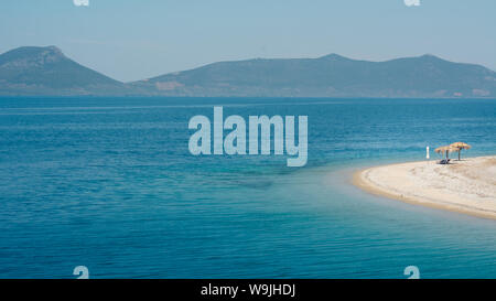 Empty beach on a Greek island with one sunshade Stock Photo