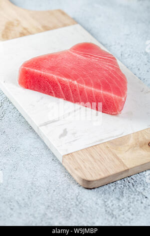Raw tuna steak on white concrete background. Stock Photo