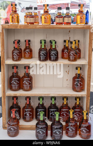 Lansdale, PA - August 10, 2019: Wooden display stand at the local farmers market is filled with Whiskey Hollow Pure Pennsylvania maple syrup made by T Stock Photo