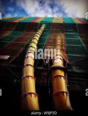 Low angle shot of a building in constriction with yellow pipes Stock Photo