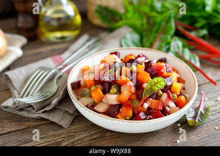Beetroot or beet salad with boiled vegetables on wooden rustic table closeup Stock Photo