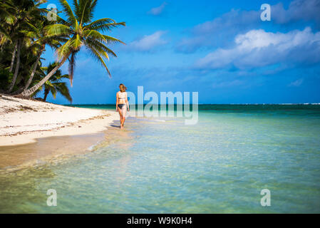 Woman walking along a tropical beach, Rarotonga Island, Cook Islands, South Pacific, Pacific Stock Photo