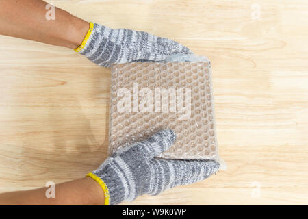 hand of man hold bubble wrap, for protection parcel product cracked or insurance During transit isolated and white background Stock Photo