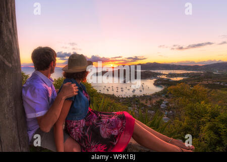 Couple look across English Harbour from Shirley Heights at sunset, Antigua, Antigua and Barbuda, Leeward Islands, West Indies, Caribbean