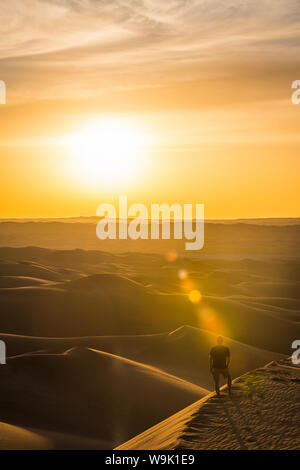 Man enjoying the sunset in the giant sand dunes of the Sahara Desert, Timimoun, western Algeria, North Africa, Africa
