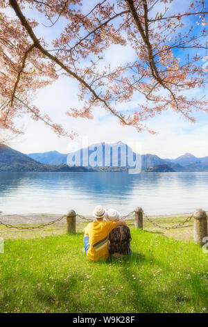 Couple of tourists sitting in frontof the lake. Lierna, Province of Lecco, Lake Como, Italian Lakes, Lombardy, Italy, Europe