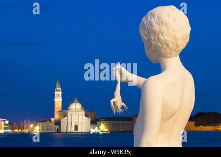 Night shot of Boy with Frog statue by Charles Ray, outside Dogana di Mare, with San Giorgio Maggiore in the distance, Venice, UNESCO, Veneto, Italy Stock Photo