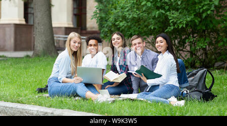 Happy college students resting in campus, smiling to camera Stock Photo