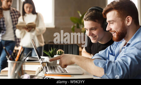 Learning concept. Students pointing at laptop's screen Stock Photo