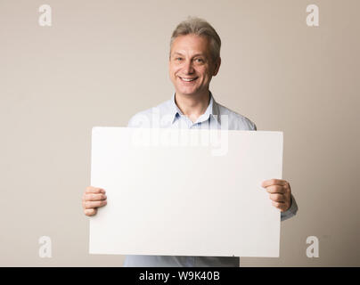 Happy mature man with blank advertising board Stock Photo