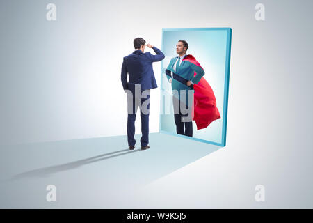 The businessman seeing himself in mirror as superhero Stock Photo - Alamy