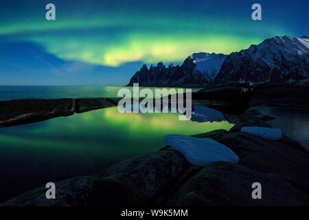 The Northern Lights (aurora borealis) and stars reflected in the icy sea, Tungeneset, Senja, Troms county, Arctic, Norway, Scandinavia, Europe Stock Photo