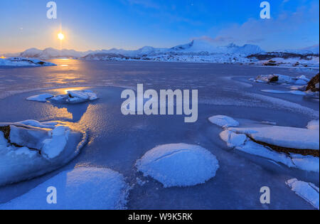 Reflections of full moon in the frozen sea, Lyngedal, Lofoten Islands, Arctic, Norway, Scandinavia, Europe Stock Photo