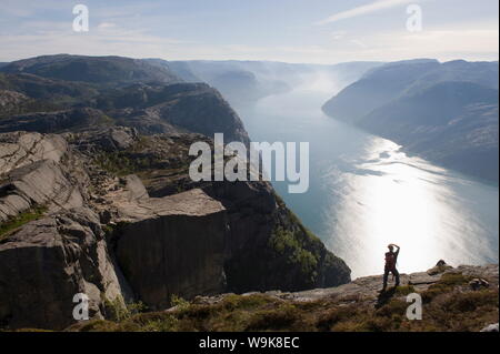 Man photographing the fjord, Preikestolen (Pulpit Rock), Lysefjord, Norway, Scandinavia, Europe Stock Photo