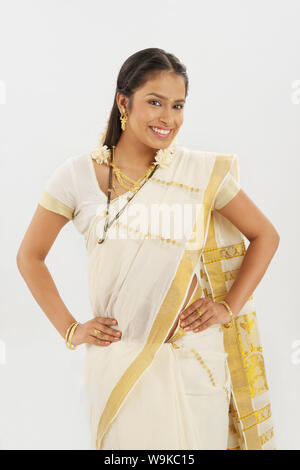 South Indian woman smiling with her arms akimbo Stock Photo