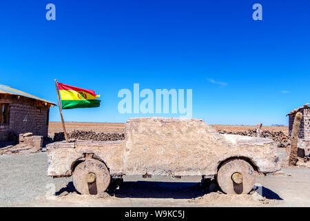 Salty Jeep sculpture and Bolivian Flag in salt flat Salar de Uyuni, Bolivia Stock Photo