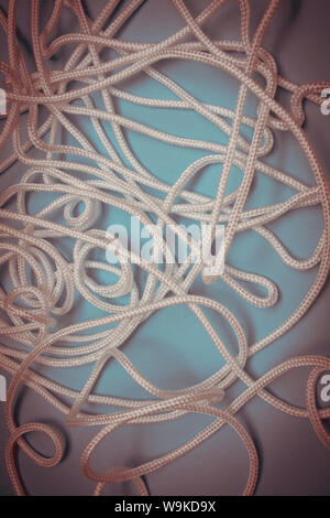 white rope or string randomly laid in a tangled mess. Stock Photo