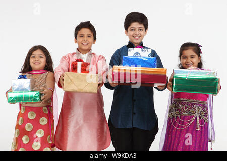 Group of children standing together and holding gift boxes Stock Photo