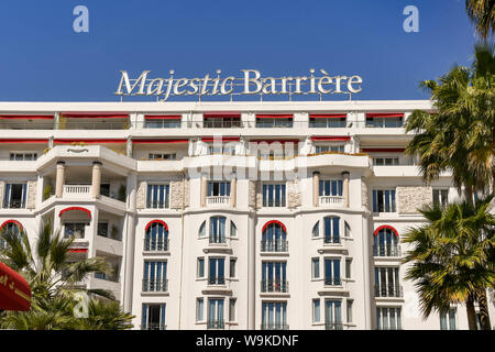CANNES, FRANCE - APRIL 2019: Front exterior view of the Majestic Barriere hotel, which is a landmark on the seafront in Cannes. Stock Photo