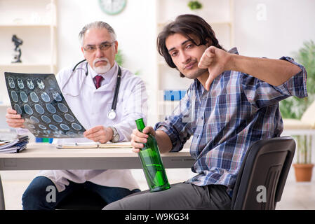 The young male alcoholic visiting old doctor Stock Photo