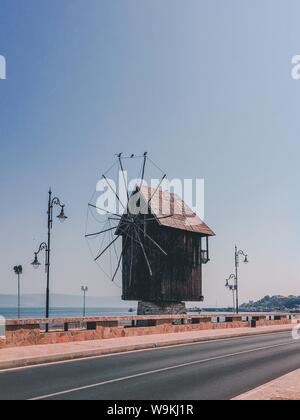 Vertical shot of a small wooden windmill on the side of the road in the countryside Stock Photo