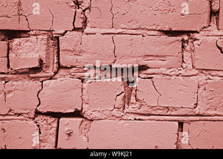Macro image of an old cracked brick wall toned in the color of living coral, creative mock up Stock Photo