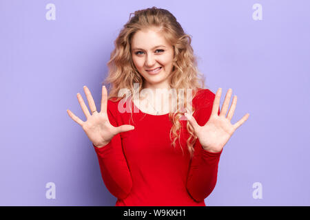 beautiful young woman asks not to involve her in problem. girl demonstrates no reply gesture, doesn't want to get in trouble, shows palms in camera, i Stock Photo