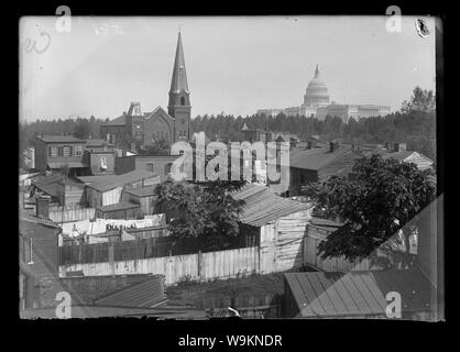 An overview of Wesley Zion Church in the midst of public housing, old wooden structures and trees; United States Capitol building on far right Stock Photo