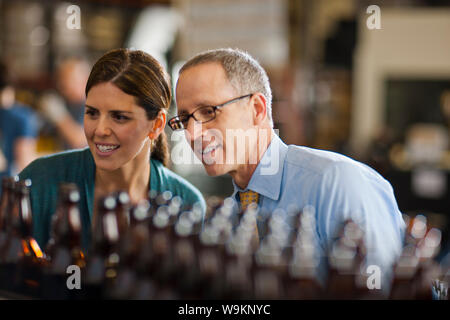 Two colleagues discussing work in a brewery. Stock Photo