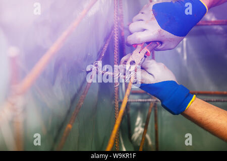 Closeup of man hands knit metal rods for basement Stock Photo