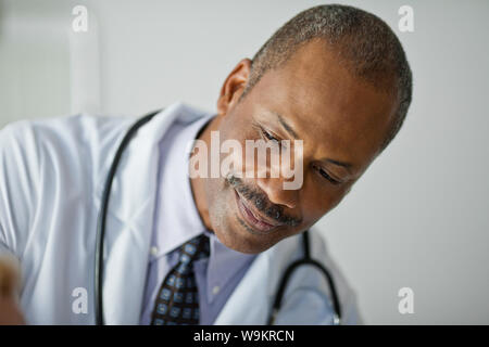 Smiling friendly doctor greets a hospital patient. Stock Photo