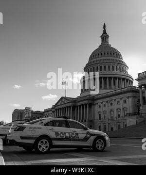 A black and white picture of a police car in front of the United States Capitol. Stock Photo