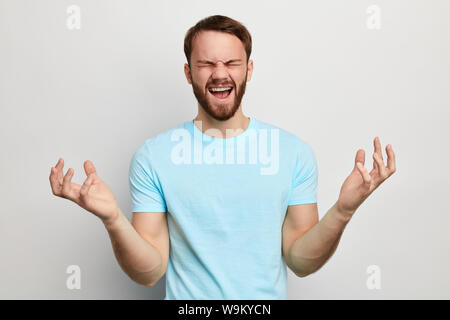 crazy handsome man showing aggressive expression. close up portrait. isolated white background. frustration concept Stock Photo