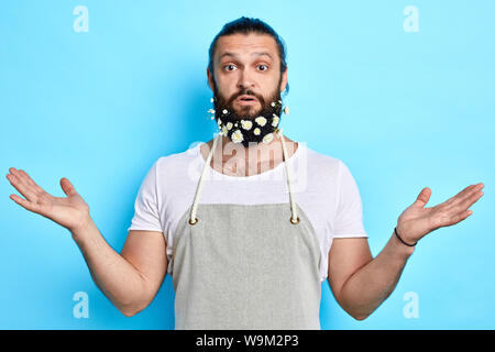 young handsome man abeing surprised at flowers in beard. close up photo. feeling and emotion. Stock Photo