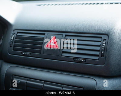 closeup of triangle red accident Stop Emergency Light Button on Car dashboard plate Stock Photo