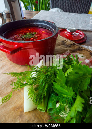 Russian borscht in red pot with garlic, parsley, dill, lard Ukrainian borscht food background, Food and health Stock Photo