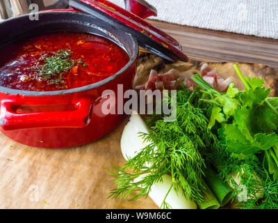 Russian borscht in red pot with garlic, parsley, dill, lard Ukrainian borscht food background, Food and health Stock Photo