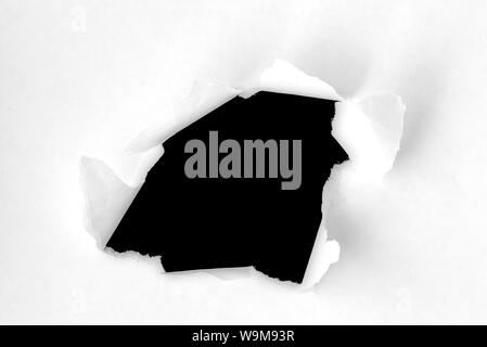 Hole in Paper and Torn sides, round hole in paper on black Background Stock Photo
