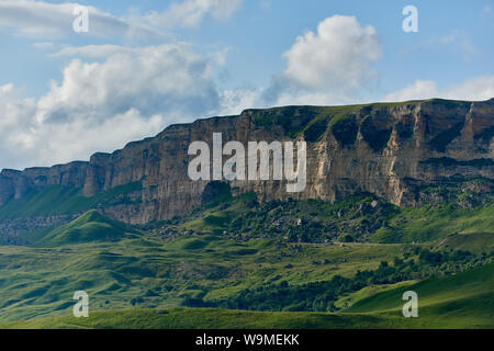 Green valley and rocky ridge under a cloudy sky. North Caucasus Russia Stock Photo