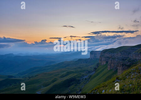 Sunset in the mountains. The sun shines through the fog over the mountain range. North Caucasus Russia Stock Photo