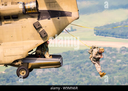 Soldier jumping out of a Chinook at 2019 Leapfest, an international static line parachute training event and competition, hosted by RI Natl. Guard. Stock Photo