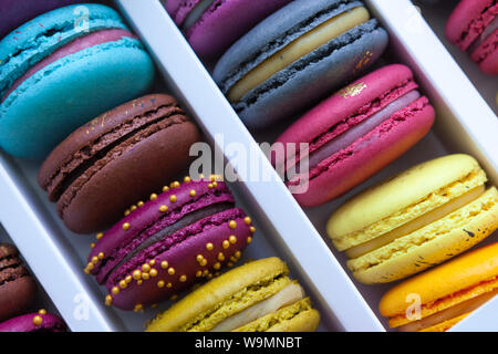 Assortment of multicolored macaroon different lie in the cardboard box with the top view. Close-up Stock Photo