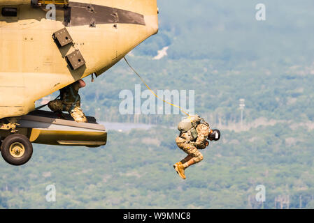 Soldier jumping out of a Chinook at 2019 Leapfest, an international static line parachute training event and competition, hosted by RI Natl. Guard. Stock Photo