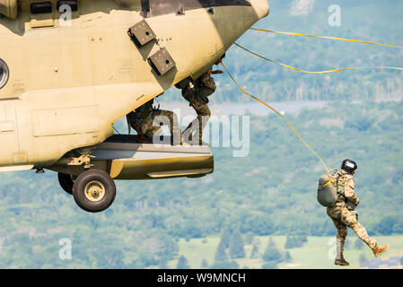 Soldier jumping out of a Chinook at 2019 Leapfest, an international static line parachute training event and competition, hosted by RI Natl. Guard. Stock Photo