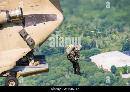 Soldier jumping out of a Chinook at 2019 Leapfest, an international static line parachute training event and competition, hosted by RI Natl. Guard. Stock Photo