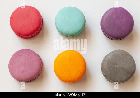 Multi-colored macaroons on a white background, french cookies as a treat for the holiday, top view Stock Photo