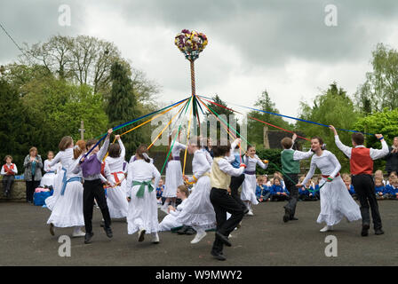 Maypole dancing May Day children dancing around the May Pole UK Charlton-on-Otmoor Oxfordshire  May Day Celebrations. Children from the Church of England St Mary the Virgin Primary School  take part in traditional May dances in the car park of the Crown Inn. 2010s 2014 HOMER SYKES Stock Photo