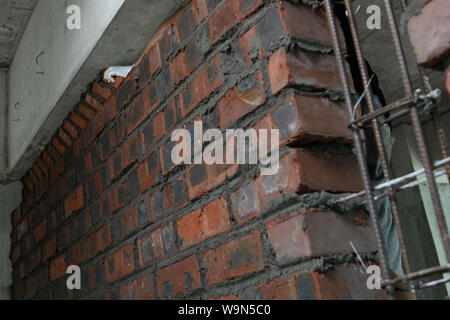plasterer making up a brick wall with cement Stock Photo