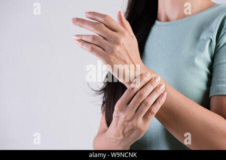 Closeup woman holds her wrist hand injury, feeling pain. Health care and medical conept. Stock Photo