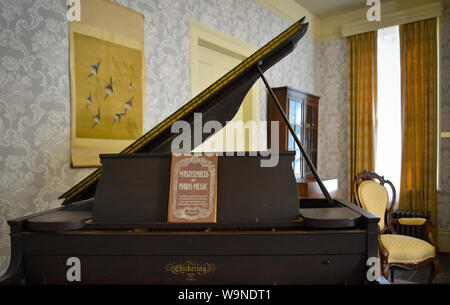 A baby grand style piano awaits an audience in the parlor at 'Rowan Oak', once the residence of pultizer prize winner, author William Faulkner, in Oxf Stock Photo